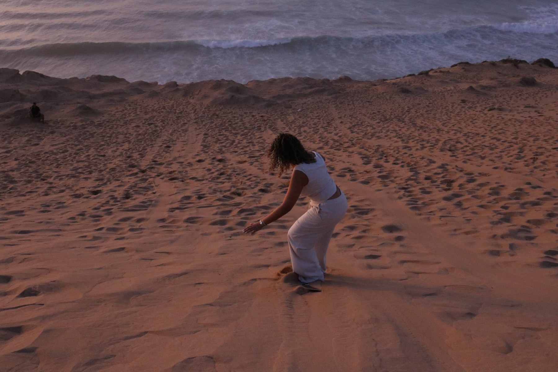 A sandboard ride at dusk beside the ocean