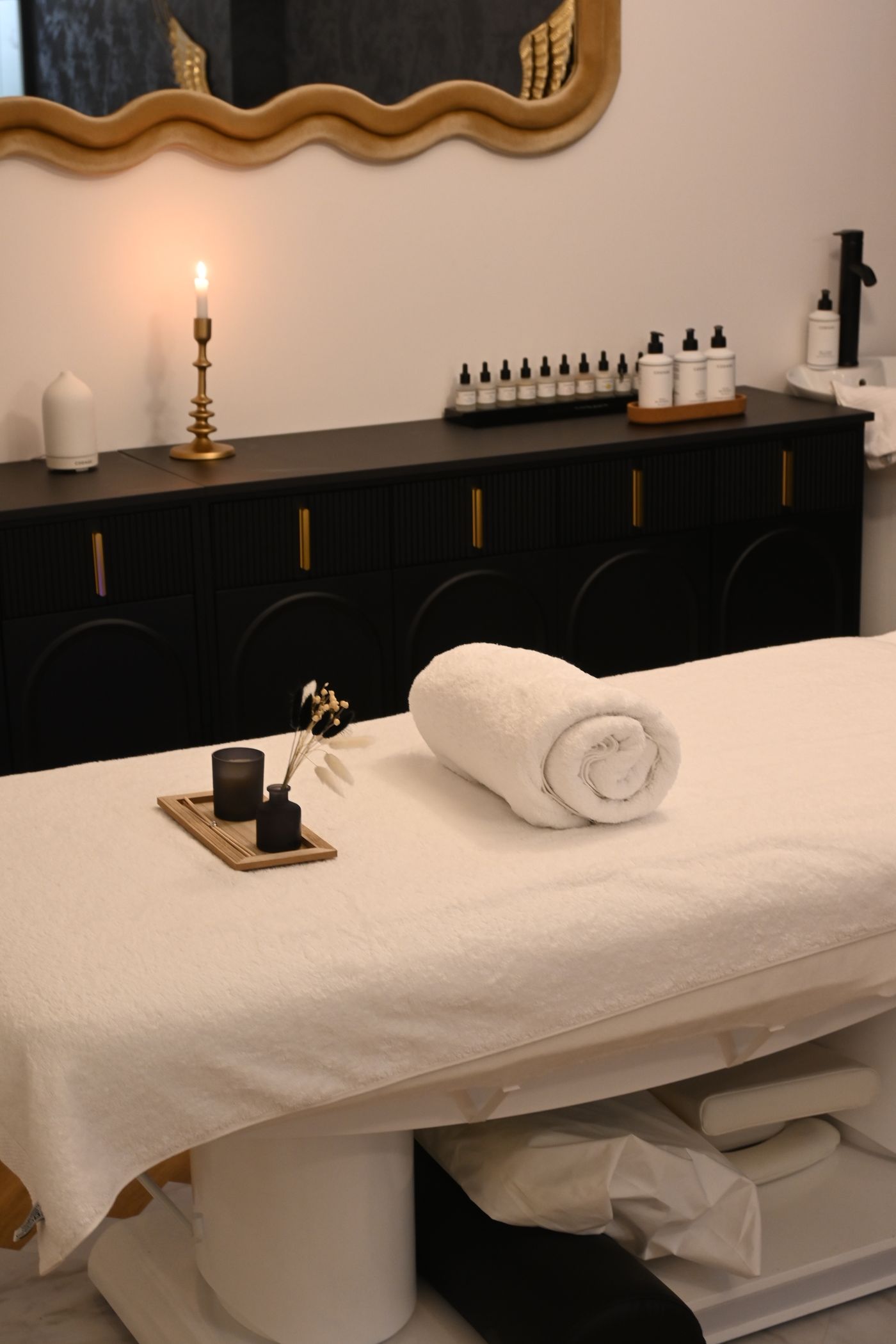 A peaceful massage room with fresh towels and candlelight